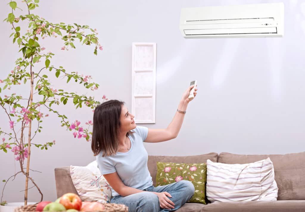 woman using remote control air conditioner
